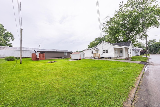 307 W Flora St, Washington, IN 47501 - view of green lawn featuring a storage unit and a porch