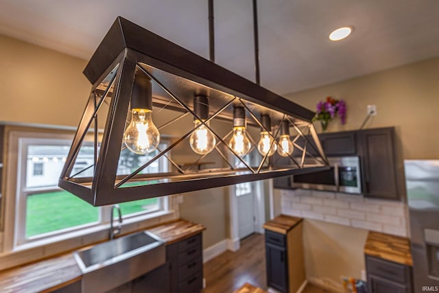 307 W Flora St, Washington, IN 47501 - kitchen with appliances with stainless steel finishes, wooden counters, wood finished floors, and decorative backsplash