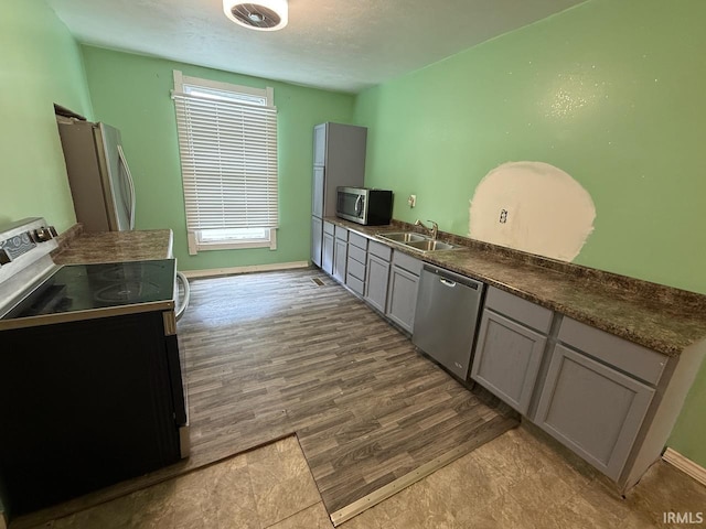 313 N Embree St, Princeton, IN 47670 - kitchen featuring appliances with stainless steel finishes, gray cabinetry, dark wood-style floors, and dark countertops