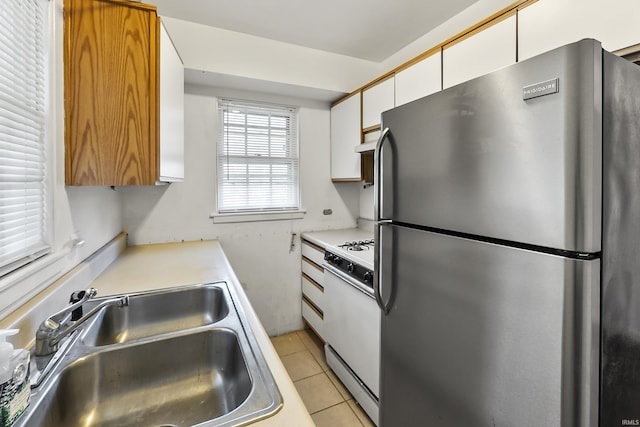 5309 S Hanna St, Fort Wayne, IN 46806 - kitchen with freestanding refrigerator, white gas range oven, white cabinets, light tile patterned floors, and light countertops