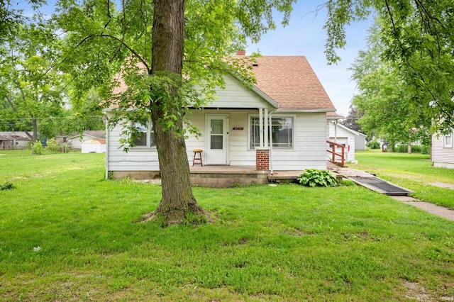 1614 E 24th St, Muncie, IN 47302 - bungalow-style home featuring a porch, a front lawn, a shingled roof, and a chimney