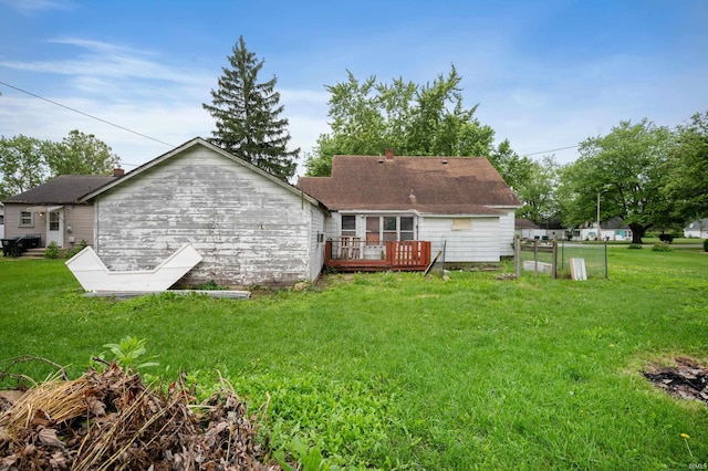 1614 E 24th St, Muncie, IN 47302 - back of house with a deck, a yard, and roof with shingles