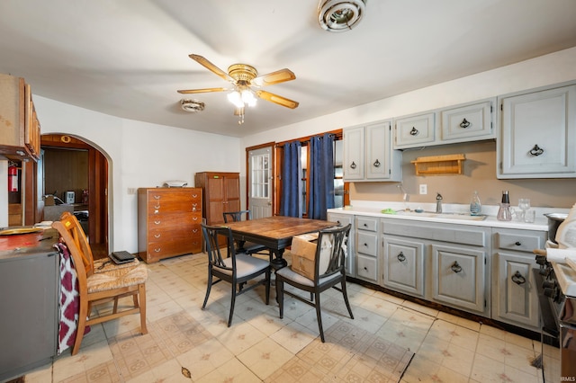 1614 E 24th St, Muncie, IN 47302 - kitchen featuring gray cabinets, a ceiling fan, arched walkways, light countertops, and light flooring
