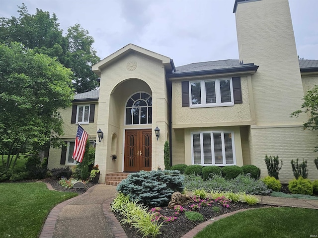 16 Johnson Pl, Evansville, IN 47714 - traditional home with a chimney, brick siding, french doors, and a front yard