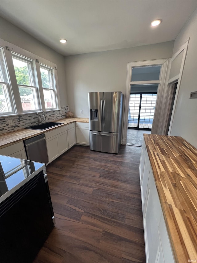 1906 N 15th St, Lafayette, IN 47904 - kitchen featuring appliances with stainless steel finishes, butcher block counters, dark wood-type flooring, decorative backsplash, and white cabinets