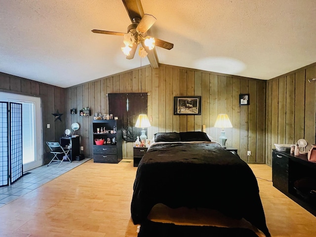 125 Shalley Dr, Plymouth, IN 46563 - bedroom with a textured ceiling, wood walls, light wood-style floors, and a ceiling fan