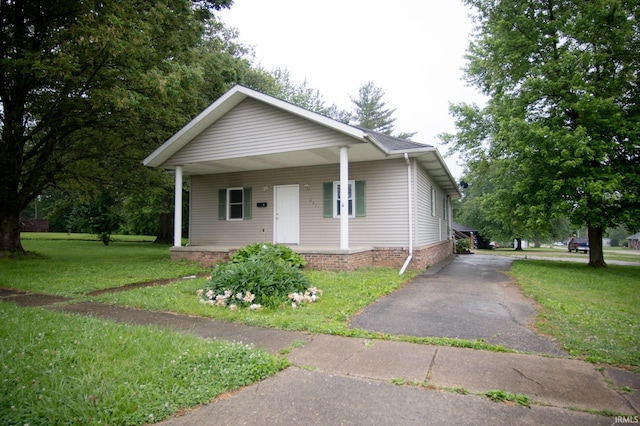 631 W 8th St, Bicknell, IN 47512 - bungalow-style home featuring a front yard, asphalt driveway, and a porch