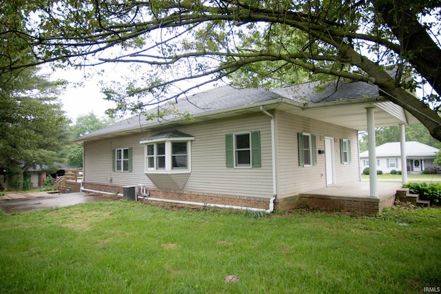 631 W 8th St, Bicknell, IN 47512 - back of house featuring a lawn, roof with shingles, and covered porch