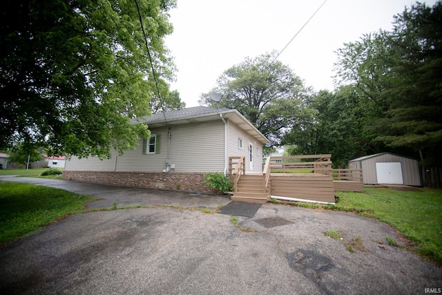 631 W 8th St, Bicknell, IN 47512 - view of home's exterior featuring a shed, brick siding, and a deck