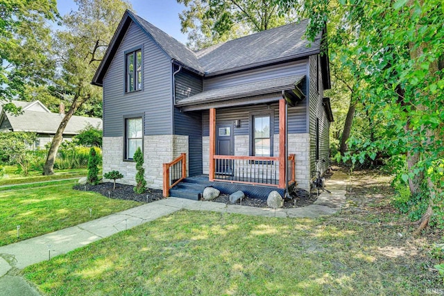 516 W Navarre St, South Bend, IN 46616 - view of front facade featuring stone siding, covered porch, a front yard, and roof with shingles