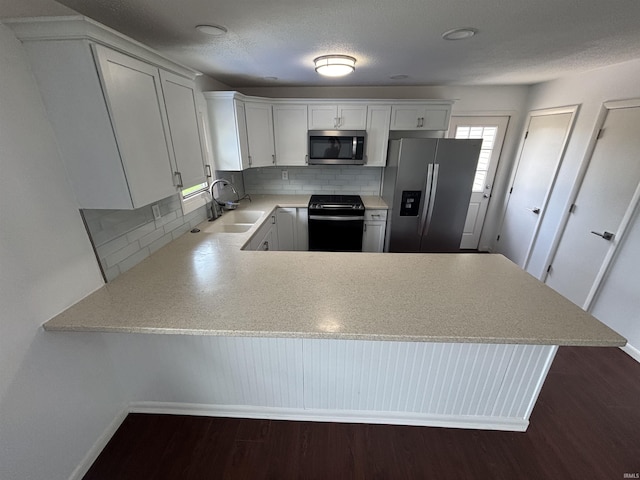 1821 E Johnson Ln, Vincennes, IN 47591 - kitchen with appliances with stainless steel finishes, a peninsula, backsplash, and light countertops