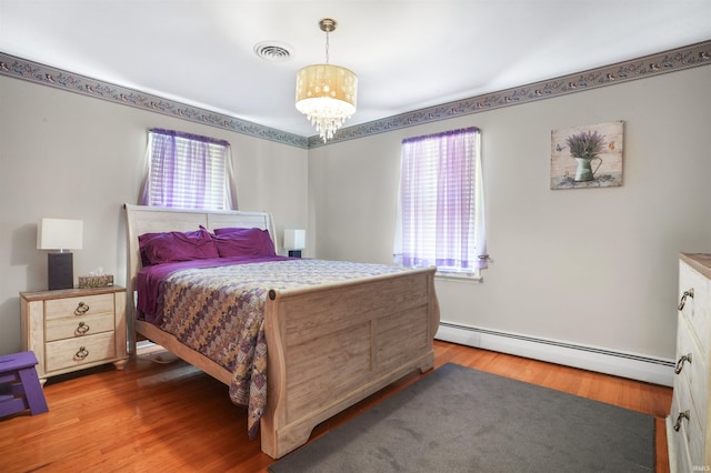 2208 Franklin St, Tell City, IN 47586 - bedroom with baseboard heating, wood finished floors, and a chandelier