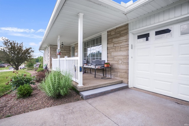 2208 Franklin St, Tell City, IN 47586 - doorway to property with covered porch, stone siding, board and batten siding, an attached garage, and driveway