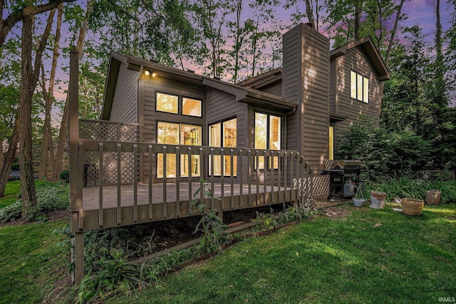 17991 Sable Ridge Dr, South Bend, IN 46635 - back of property at dusk featuring a chimney, a yard, and a wooden deck