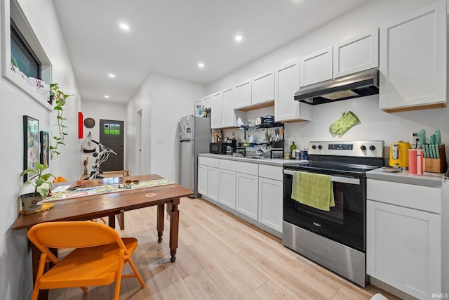 622 Romig St, Lafayette, IN 47901 - kitchen featuring stainless steel electric range oven, under cabinet range hood, freestanding refrigerator, black microwave, and white cabinetry