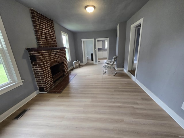 107 W S B St, Gas City, IN 46933 - unfurnished living room featuring light wood-type flooring and a fireplace