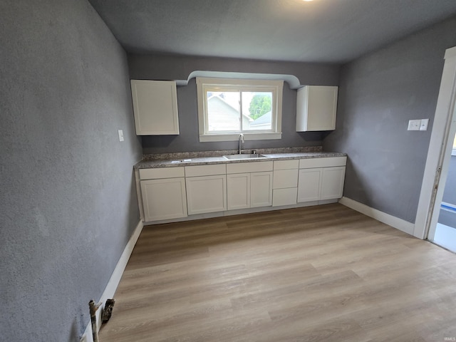 107 W S B St, Gas City, IN 46933 - kitchen with white cabinets, light wood finished floors, a textured wall, and dark countertops
