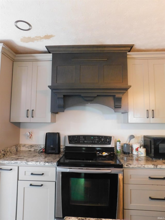 4597 S W Washington School Rd, Salem, IN 47167 - kitchen with electric range, black microwave, light stone countertops, and custom exhaust hood