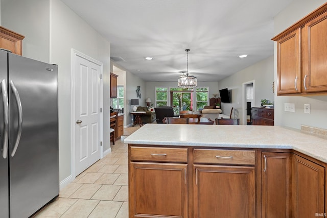 233 Sinclair Dr, West Lafayette, IN 47906 - kitchen featuring freestanding refrigerator, a peninsula, open floor plan, brown cabinets, and light countertops