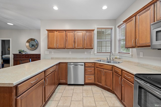 233 Sinclair Dr, West Lafayette, IN 47906 - kitchen with appliances with stainless steel finishes, brown cabinets, a peninsula, light countertops, and recessed lighting