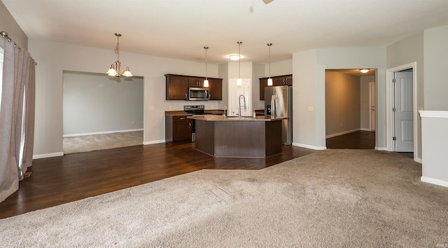 2410 Trillium Cv, Huntertown, IN 46748 - kitchen featuring appliances with stainless steel finishes, open floor plan, dark colored carpet, and a chandelier