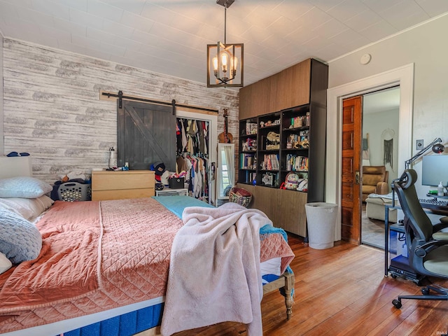 3020 Parnell Ave, Fort Wayne, IN 46805 - bedroom with a barn door, a chandelier, hardwood / wood-style flooring, and a closet