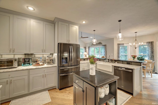 5007 W Michael Ln, Bloomington, IN 47404 - kitchen with appliances with stainless steel finishes, a peninsula, light wood-style floors, recessed lighting, and lofted ceiling