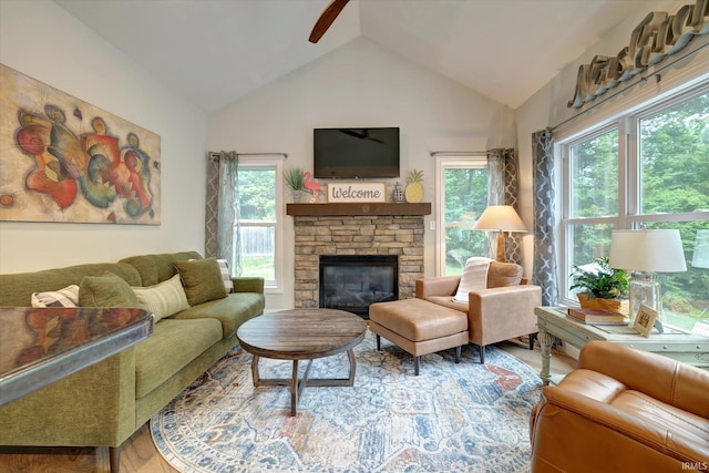 5007 W Michael Ln, Bloomington, IN 47404 - living room featuring a ceiling fan, vaulted ceiling, a stone fireplace, plenty of natural light, and wood finished floors