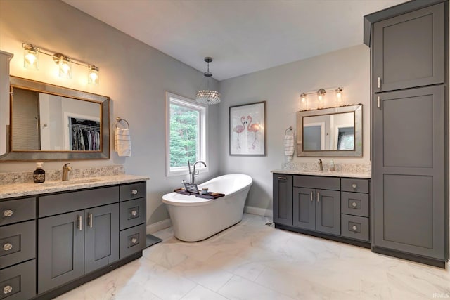 5007 W Michael Ln, Bloomington, IN 47404 - bathroom featuring marble look tile flooring, two vanities, a soaking tub, and a spacious closet