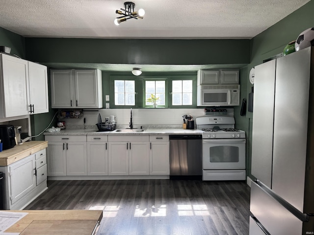 562 Railroad St, Wabash, IN 46992 - kitchen with white appliances, dark wood-type flooring, a textured ceiling, light countertops, and white cabinetry