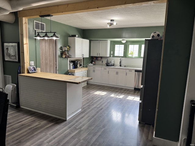 562 Railroad St, Wabash, IN 46992 - kitchen with stainless steel appliances, a peninsula, dark wood-type flooring, white cabinetry, and a textured ceiling