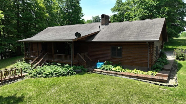 4115 N Aquarius Dr, Monticello, IN 47960 - back of house with log exterior, a lawn, and a chimney