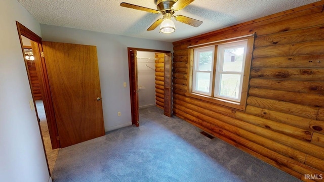 4115 N Aquarius Dr, Monticello, IN 47960 - unfurnished bedroom featuring carpet flooring, rustic walls, a textured ceiling, a closet, and ceiling fan