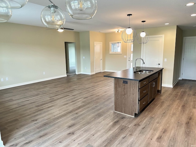 1466 Monte Carlo Dr, Huntertown, IN 46748 - kitchen featuring dark countertops, wood finished floors, open floor plan, a center island with sink, and recessed lighting