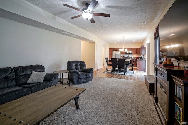 140 Wadsworth Ct, Lafayette, IN 47905 - living area featuring a textured ceiling, light colored carpet, ceiling fan, and light wood finished floors