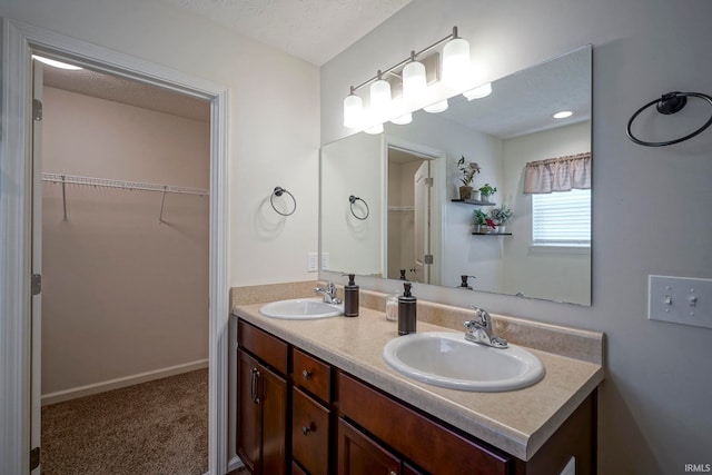 140 Wadsworth Ct, Lafayette, IN 47905 - bathroom featuring double vanity, a spacious closet, and a textured ceiling