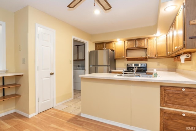 3718 Grasstree Ct, Bloomington, IN 47401 - kitchen featuring stainless steel appliances, washer / dryer, a peninsula, a ceiling fan, and light countertops