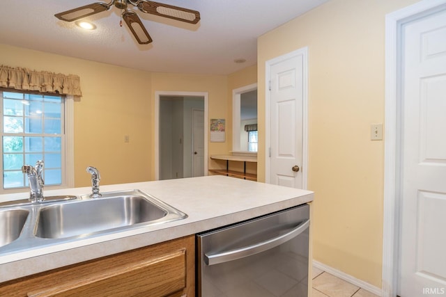 3718 Grasstree Ct, Bloomington, IN 47401 - kitchen with stainless steel dishwasher, brown cabinetry, light tile patterned flooring, light countertops, and ceiling fan