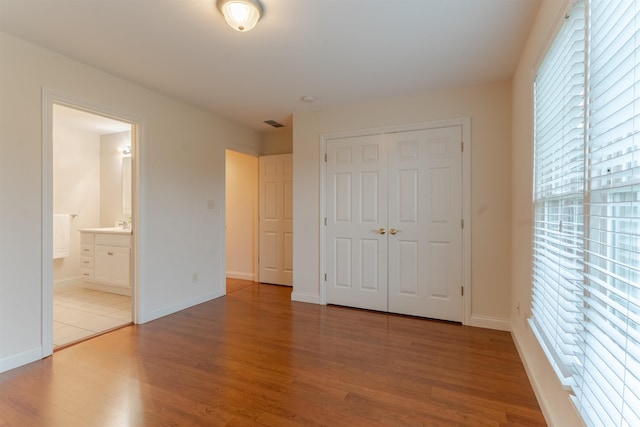 7561 Saint Jordan Cir, Newburgh, IN 47630 - unfurnished bedroom with multiple windows, wood finished floors, and a closet