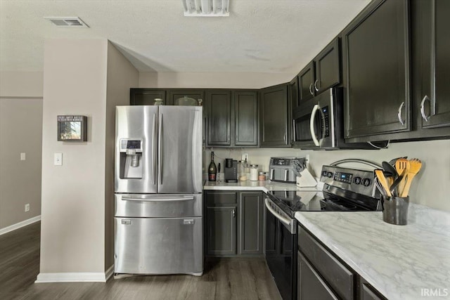 3933 Electra Ct, Lafayette, IN 47905 - kitchen featuring stainless steel appliances, dark wood-style floors, light stone counters, and a textured ceiling