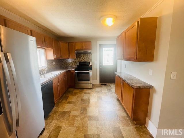 608 W Main St, Greentown, IN 46936 - kitchen featuring freestanding refrigerator, electric range, black dishwasher, under cabinet range hood, and brown cabinets