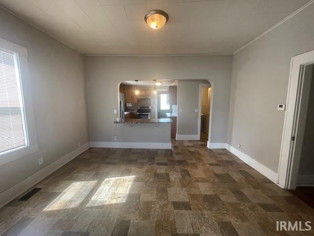 608 W Main St, Greentown, IN 46936 - unfurnished living room featuring arched walkways and ornamental molding