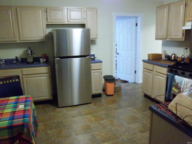 917 N Maple St, Bloomington, IN 47404 - kitchen with freestanding refrigerator, range, dark countertops, extractor fan, and stone finish flooring