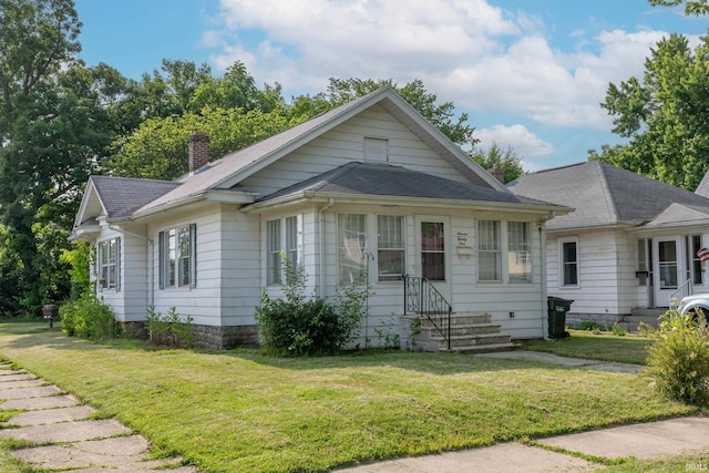 1121 S 23rd St, South Bend, IN 46615 - view of front facade featuring entry steps, a chimney, a front lawn, and a shingled roof