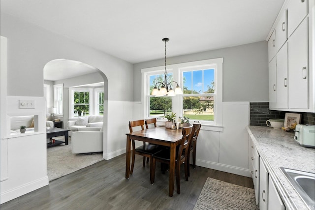 428 E Washington St, Bluffton, IN 46714 - dining room with arched walkways, dark wood-style floors, a wainscoted wall, and a chandelier