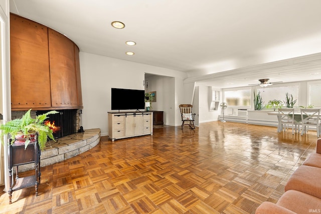 1208 Delta Blvd, Fort Wayne, IN 46805 - living room featuring recessed lighting, a ceiling fan, a warm lit fireplace, and baseboard heating