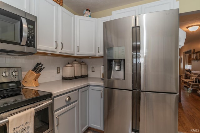 4600 N Shadow Wood Dr, Bloomington, IN 47404 - kitchen with appliances with stainless steel finishes, light countertops, decorative backsplash, wood finished floors, and gray cabinetry