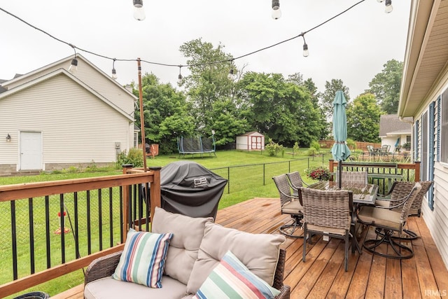 4600 N Shadow Wood Dr, Bloomington, IN 47404 - wooden terrace with a trampoline, outdoor dining area, a storage shed, and a grill