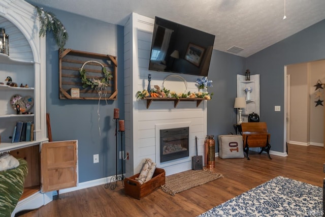 4600 N Shadow Wood Dr, Bloomington, IN 47404 - living area featuring a fireplace, wood finished floors, lofted ceiling, and a textured ceiling