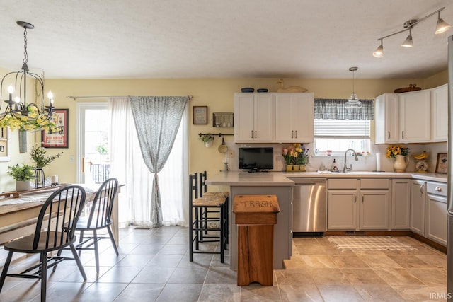 4600 N Shadow Wood Dr, Bloomington, IN 47404 - kitchen with dishwasher, plenty of natural light, a chandelier, light countertops, and a textured ceiling